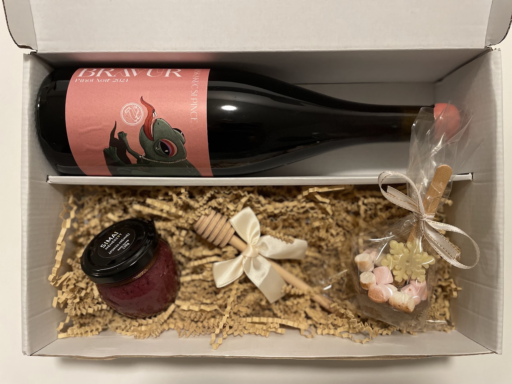 Ajándékdoboz Bravúr Pinot Noir palackkal, áfonyás krémmézzel, mézcsurgatóval és mályvacukros forró csokival.